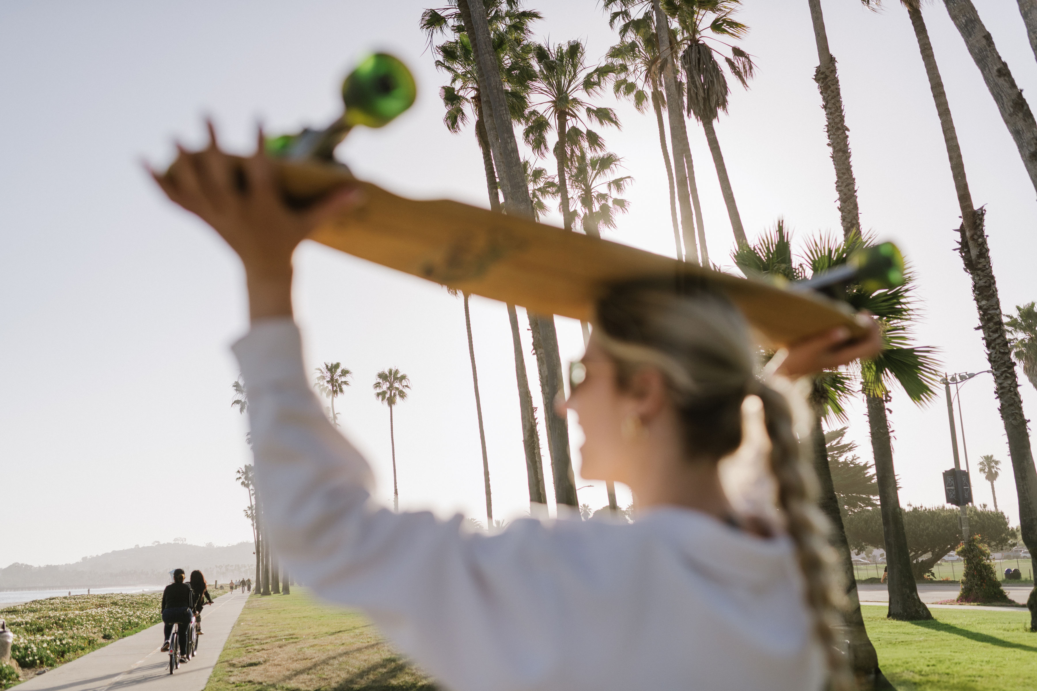 female westmont student holding longboard over head