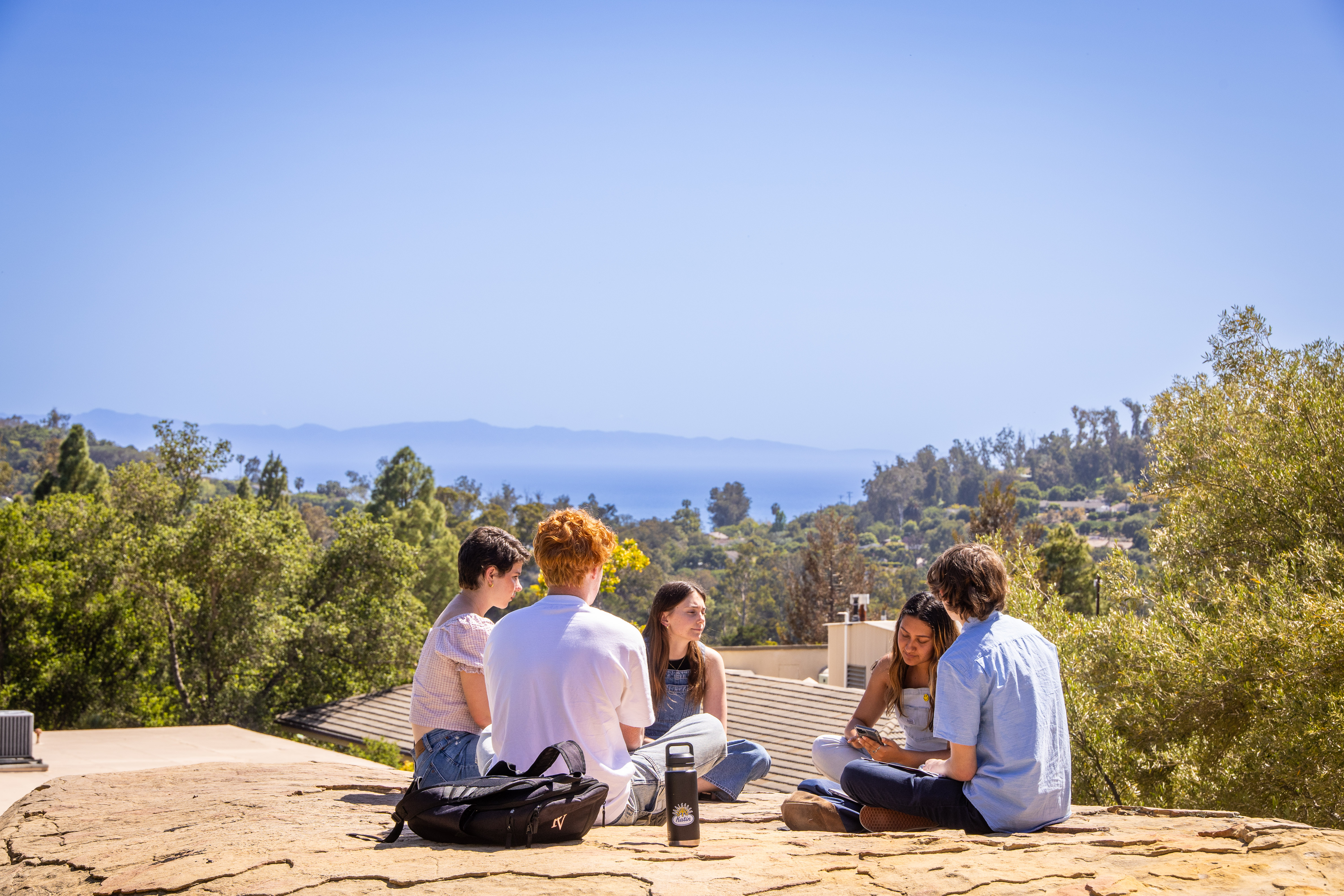 students sitting on rock